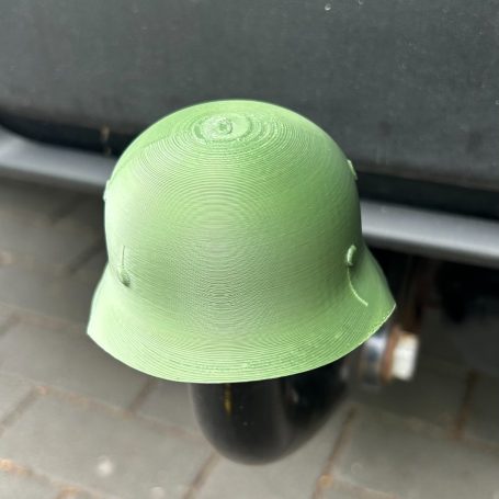 Grüner Helm, der an einem Fahrzeug befestigt ist.
