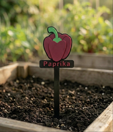 Ein Gartenstecker mit der Aufschrift "Paprika" und einer Illustration einer Paprika.
