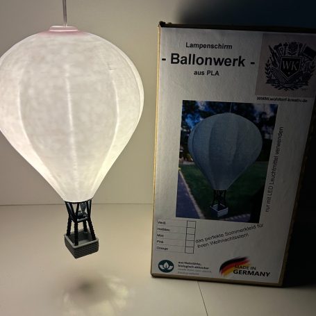 Heißluftballon-Modell mit Kartonverpackung im Hintergrund.