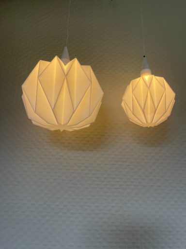 Zwei hängende Lampen in Blumenform, die warmes Licht ausstrahlen.