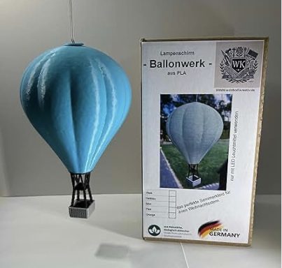 Hellblaue Heißluftballon-Modell mit Verpackung im Hintergrund.