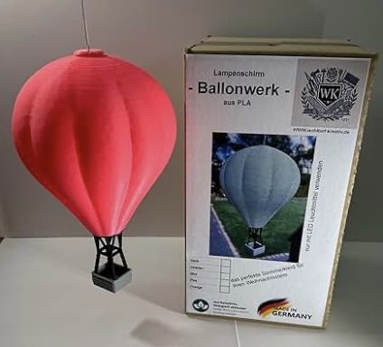 Rote Heißluftballon-Modell neben einer Verpackung.