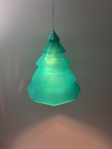 Grüne Weihnachtsbaum-Lampe hängend, mit mehreren stilisierten Schichten.