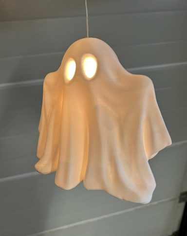 Eine leuchtende Geisterlampe mit weißen Tuchfalten und leuchtenden Augen.