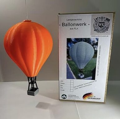 Orange Luftballon-Modell mit Verpackung im Hintergrund.