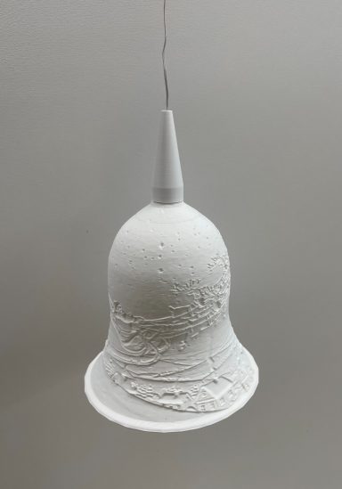 Weiße Glocke mit strukturierter Oberfläche, hängend an einem dünnen Faden.