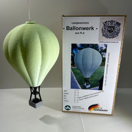 Modell eines Heißluftballons neben einer Verpackung mit Anleitung.