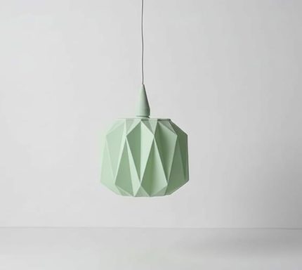 Mintgrüner, geometrisch geformter Lampenschirm hängt von der Decke.