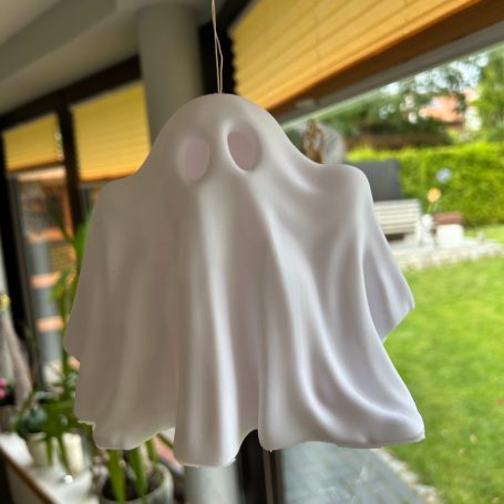 Eine weißer Geisterfigur mit zwei Augenlöchern hängt in einem Raum.