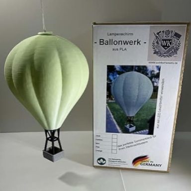 Grüne Papier-Luftballonmodell mit Verpackung im Hintergrund.