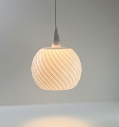 Weiße Pendelleuchte mit gewellter Oberfläche und sanftem Licht.