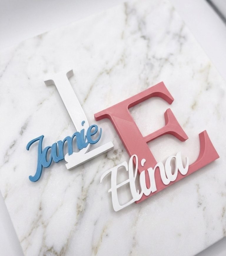 Bunte Buchstaben "Jamie" und "Elina" auf einem marmorierten Hintergrund.